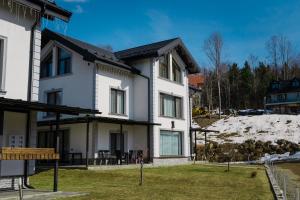 a white house with a hill in the background at Royal Alpin Crown in Cavnic