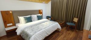 a hotel room with a large bed and chairs at Private Villa Alpine Escape 6BHK in Manāli
