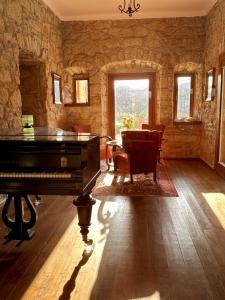 a living room with a piano in a stone wall at Úrágya Vendégház in Mád +22 photos