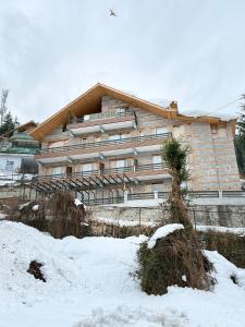 a large building in the snow in front at Private Villa Alpine Escape 6BHK in Manāli