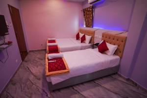 two beds in a room with purple and purple at P V Grand in Dindigul