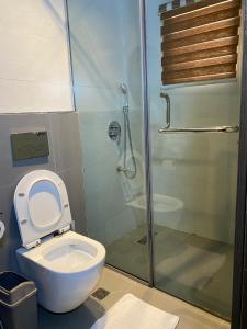 a bathroom with a toilet and a glass shower at Greyfield Apartment 1 in Benin City