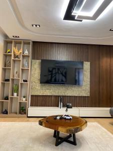 a living room with a tv and a coffee table at Greyfield Apartment 1 in Benin City