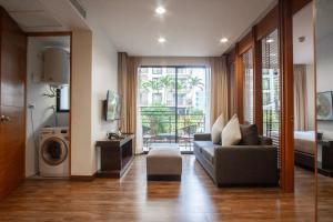 a living room with a couch and a washing machine at Amanta Hotel & Residence Ratchada in Bangkok
