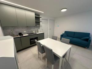 a living room with a table and a blue couch at White Suite Lakeside in Colonno