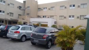 un grupo de autos estacionados en un estacionamiento frente a un edificio en Novo Hotel Herta, en Guaíra