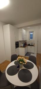 a kitchen with a table with a bowl of flowers on it at Apartment Green Lux in Belgrade +15 photos