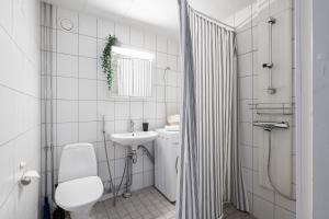 a white bathroom with a toilet and a sink at Spacious Downtown Apt with Balcony - Hosts 10 in Tampere