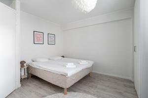 a bedroom with a bed in a white room at Spacious Downtown Apt with Balcony - Hosts 10 in Tampere