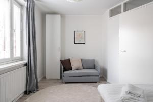 a white room with a chair and a window at Spacious Downtown Apt with Balcony - Hosts 10 in Tampere