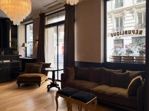 a living room with a couch and a table at New Hotel République in Paris +49 photos