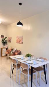 a dining room with a white table and chairs at The HappyNest Tagum in Tagum