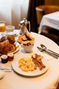 a table with plates of breakfast food on it at The Originals Boutique, Hôtel Les Poèmes de Chartres in Chartres
