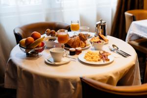 a table with breakfast foods and drinks on it at The Originals Boutique, Hôtel Les Poèmes de Chartres in Chartres +23 photos