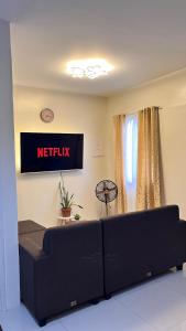 a living room with a couch and ametix sign on the wall at The HappyNest Tagum in Tagum