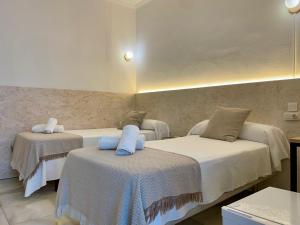 a room with three beds with white sheets at BOHEMIA SANLUCAR in Sanlúcar de Barrameda