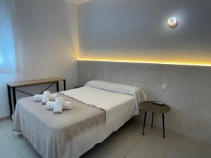 a bedroom with a bed with towels on it at BOHEMIA SANLUCAR in Sanlúcar de Barrameda