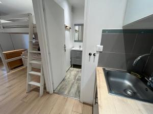 a small bathroom with a sink and a bunk bed at studio coquet et tranquille in Porquerolles +6 photos