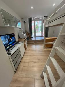 a kitchen with white cabinets and a staircase in a room at studio coquet et tranquille in Porquerolles