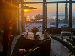 a patio with a table and a view of the sunset at Villa Velta Calagrande in Porto Santo Stefano