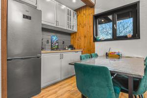 a kitchen with a table and chairs and a refrigerator at Cabana Alpinest & Sauna in Bran +109 photos