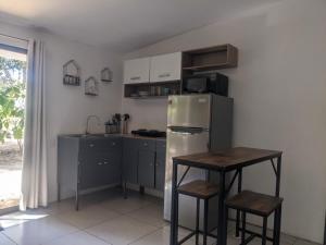 a kitchen with a stainless steel refrigerator and a table at The Paradise Jungle Studio in Coco