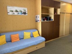 a blue couch with yellow pillows in a room at The Lookout in Ghiffa