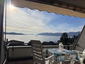 a table and chairs on a balcony with a view of the water at The Lookout in Ghiffa