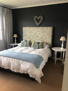 a bedroom with a large bed with a heart headboard at Lake Zonk Cottage in Mooiriver