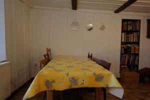 a dining room with a table with a yellow table cloth at Ferme en pleine nature in Boudevilliers