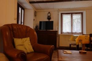 a living room with a chair and a television at Ferme en pleine nature in Boudevilliers