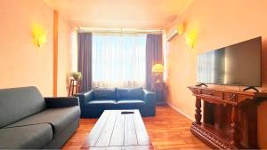 a living room with a couch and a flat screen tv at 威尼斯Mestre火车站明亮舒适便捷整套公寓Casa Marco in Marghera