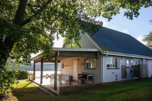 a white house with a table in front of it at Lake Zonk Cottage in Mooiriver