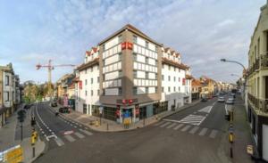 a large white building on a city street at Appartement De panne in De Panne