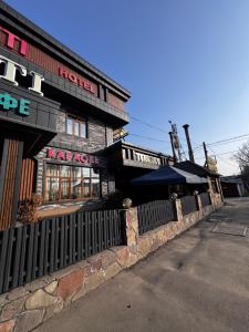a restaurant with a fence in front of a building at Imereti in Almaty