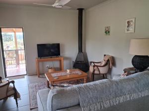 a living room with a couch and a stove at Rivergrace Farm in Robertson +26 photos