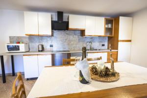 a kitchen with a table with a bottle of wine at Appartamenti dei Maerins in Pozza di Fassa +14 photos