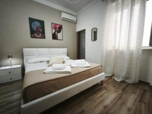 a bedroom with a large bed with two towels on it at B&B Ampelea in Gallipoli