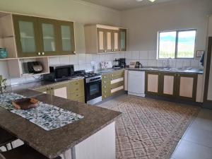 a kitchen with white cabinets and a counter top at Rivergrace Farm in Robertson