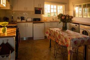 a kitchen with a table with a vase of flowers on it at Lake Zonk Cottage in Mooiriver