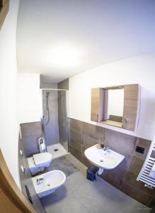 a bathroom with two sinks and a shower at Appartamenti dei Maerins in Pozza di Fassa