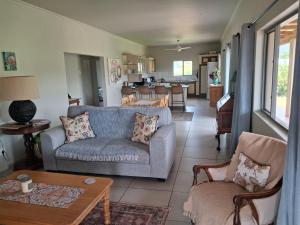 a living room with a couch and chairs and a table at Rivergrace Farm in Robertson