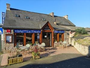 a restaurant with tables and chairs in front of a building at Studios - Location de vacances Le Trécelin in Plévenon