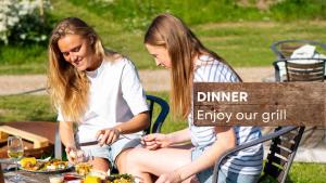 two women sitting on a bench with a plate of food at Krusmølle Glamping in Aabenraa +70 photos