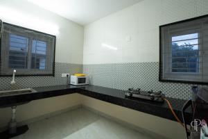 a bathroom with a sink and a microwave at Aafiya lakeview Apartments in Coimbatore