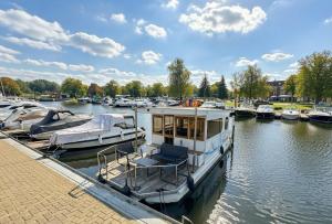 a boat docked at a marina with other boats at Hausboot in Berlin, festliegend im Yachthafen Schmöckwitz, mit Heizung in Berlin