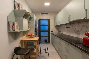 a kitchen with a small table and two stools at VillasRoyale Rex - no steps, easy access, heated pool & BBQ in Meloneras