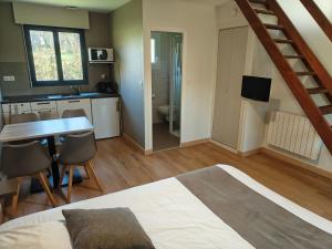 a bedroom with a bed and a table and a bathroom at Studios - Location de vacances Le Trécelin in Plévenon