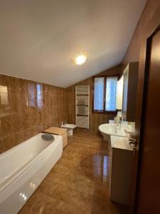 a bathroom with a tub and two sinks and a toilet at Casa Rustica - Camere in Torri di Quartesolo