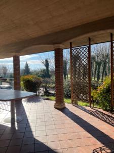 a patio with a table and a view of a garden at Casa Rustica - Camere in Torri di Quartesolo